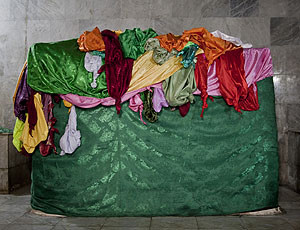 The tomb of Sheikh ʿAdī, draped with brightly colored satin cloths, appears as a peacock or a rainbow.